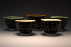 a group of teabowls: black with carved patterns