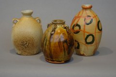 A trio of bottles (from left to right): ash/salt over tile 6 slip with shino interior; amber glaze over slips; slip layering via wax resist.